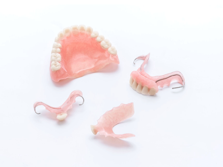 Four different dental prosthetics, including both full and partial sets, used for replacing missing teeth.