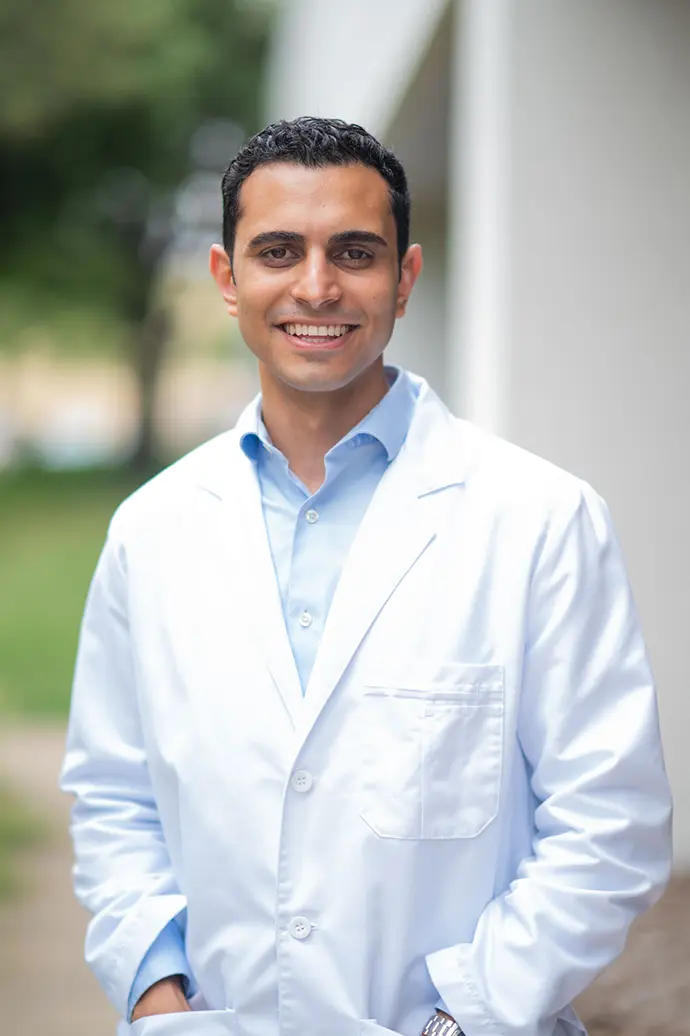 Portrait of a smiling dentist in a white coat representing Covenant Dental.